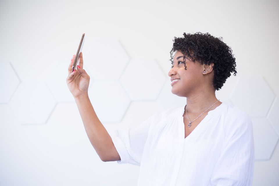 Une jeune femme souriante regarde son téléphone